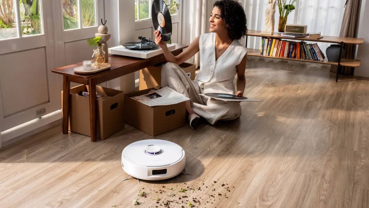 Aspirateur robot nettoyant de la terre renversée sur un parquet de salon
