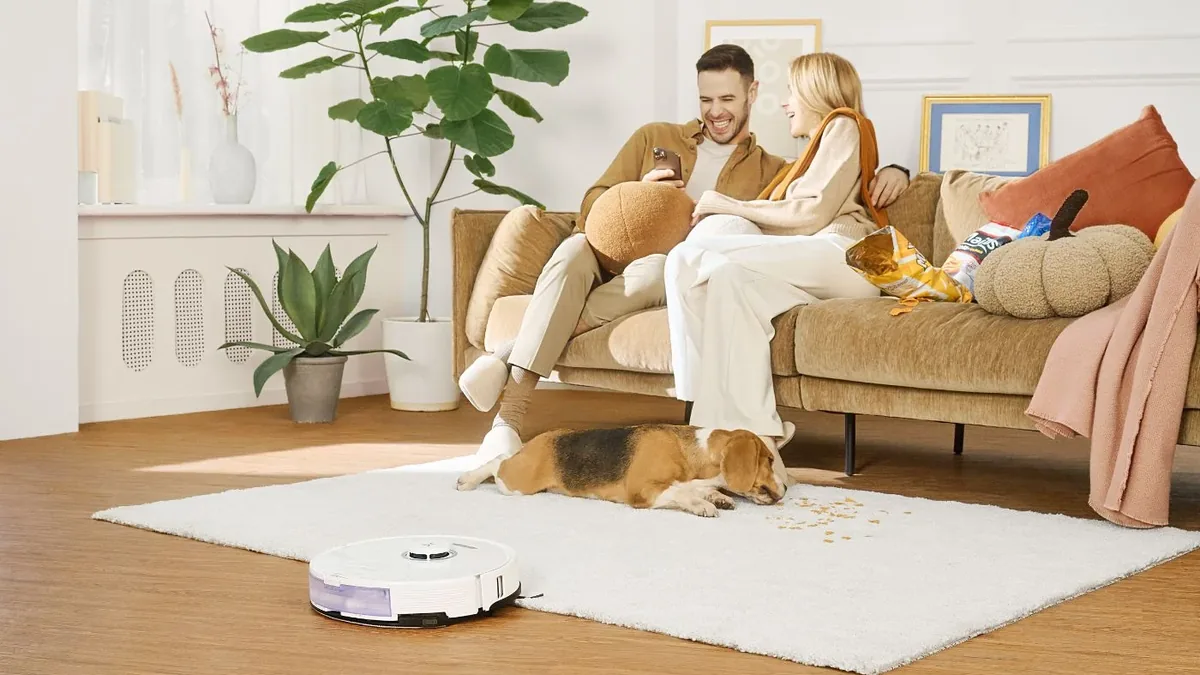 Aspirateur robot Roborock passant du parquet a un tapis dans un salon