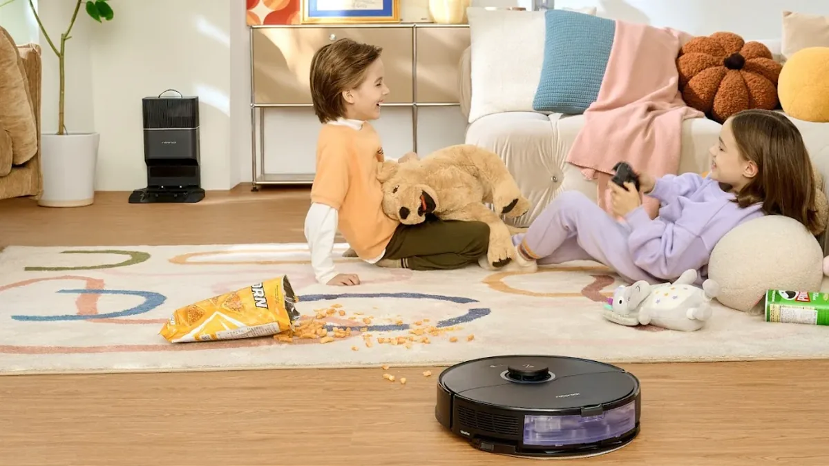 Aspirateur robot et sa station d'auto-vidage installée contre le mur d'un salon