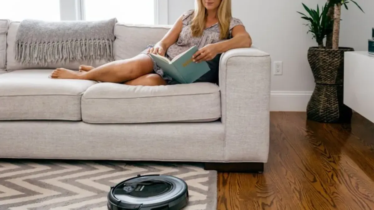 Aspirateur robot franchissant un tapis a poils courts dans un salon
